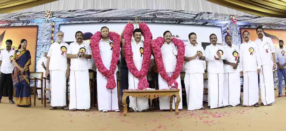 மேடையில் டி.ஆர்.பாலுவின் செருப்பை தூக்கி சுமந்த தொண்டர்